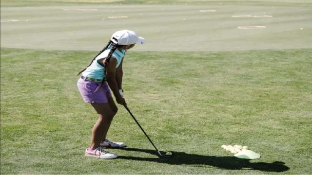 A girl golfer hitting a shot on the golf course