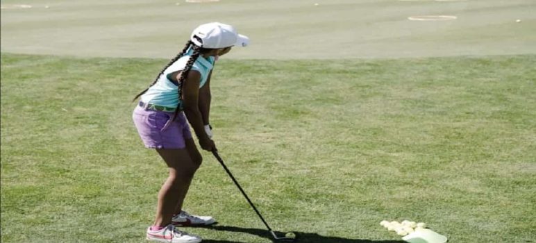 A girl golfer hitting a shot on the golf course