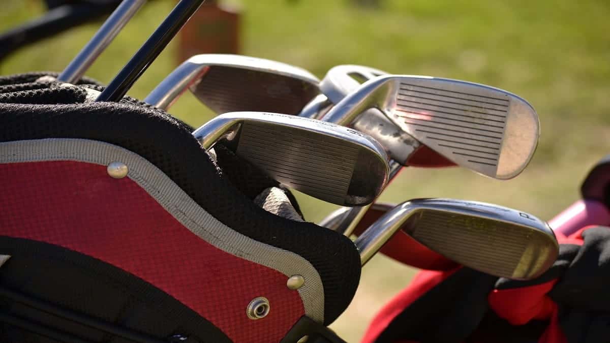 Golf clubs in bag on a golf field.